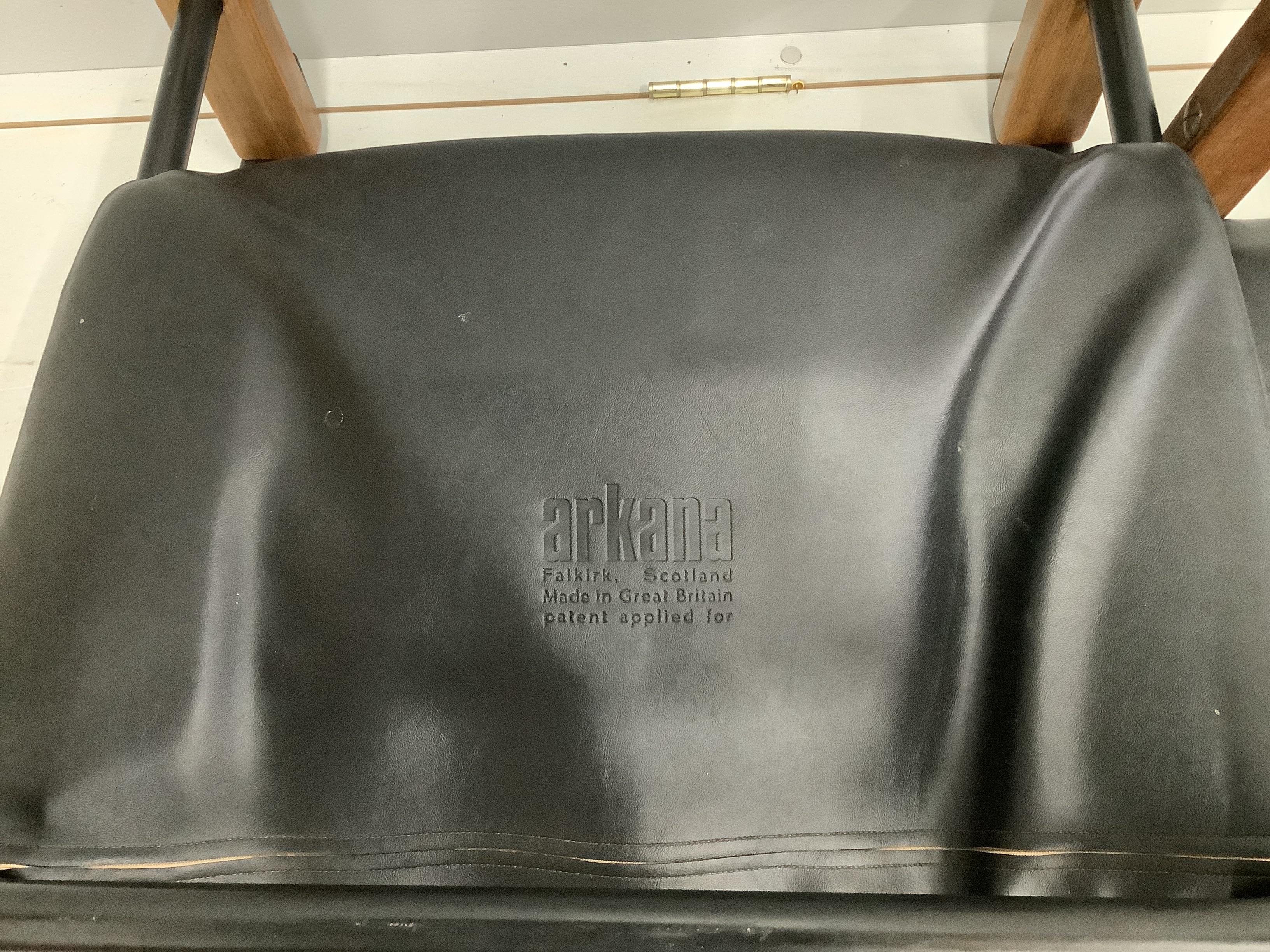 Maurice Burke for Arkana, a black leather and teak safari armchair, width 62cm, depth 60cm, height 72cm and foot stool